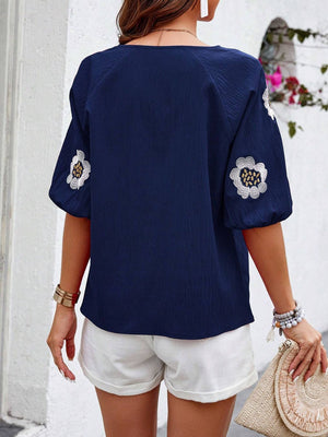 Dark blue blouse with embroidered floral yoke and puff sleeves.