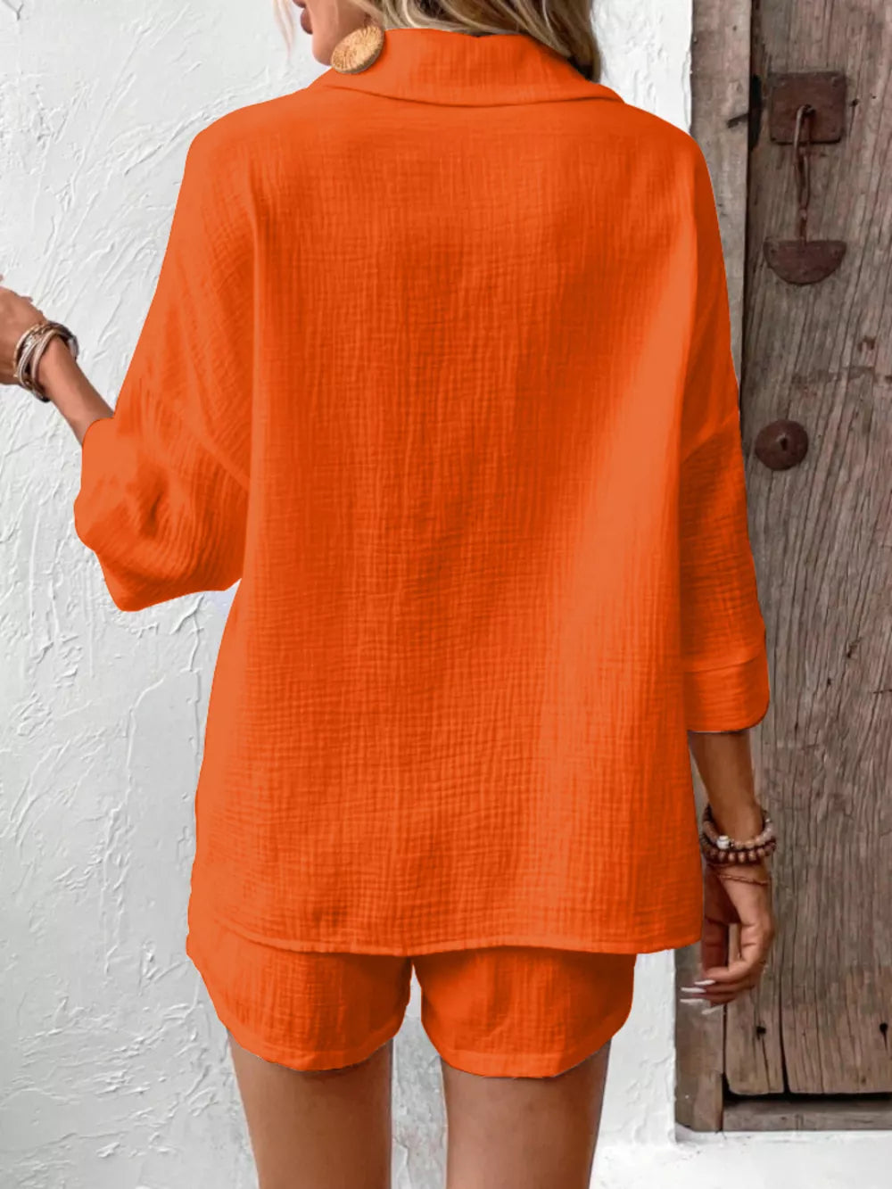Orange-red cotton two-piece set with button detail and loose fit shorts.