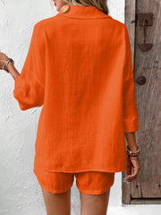Orange-red cotton two-piece set with button detail and loose fit shorts.