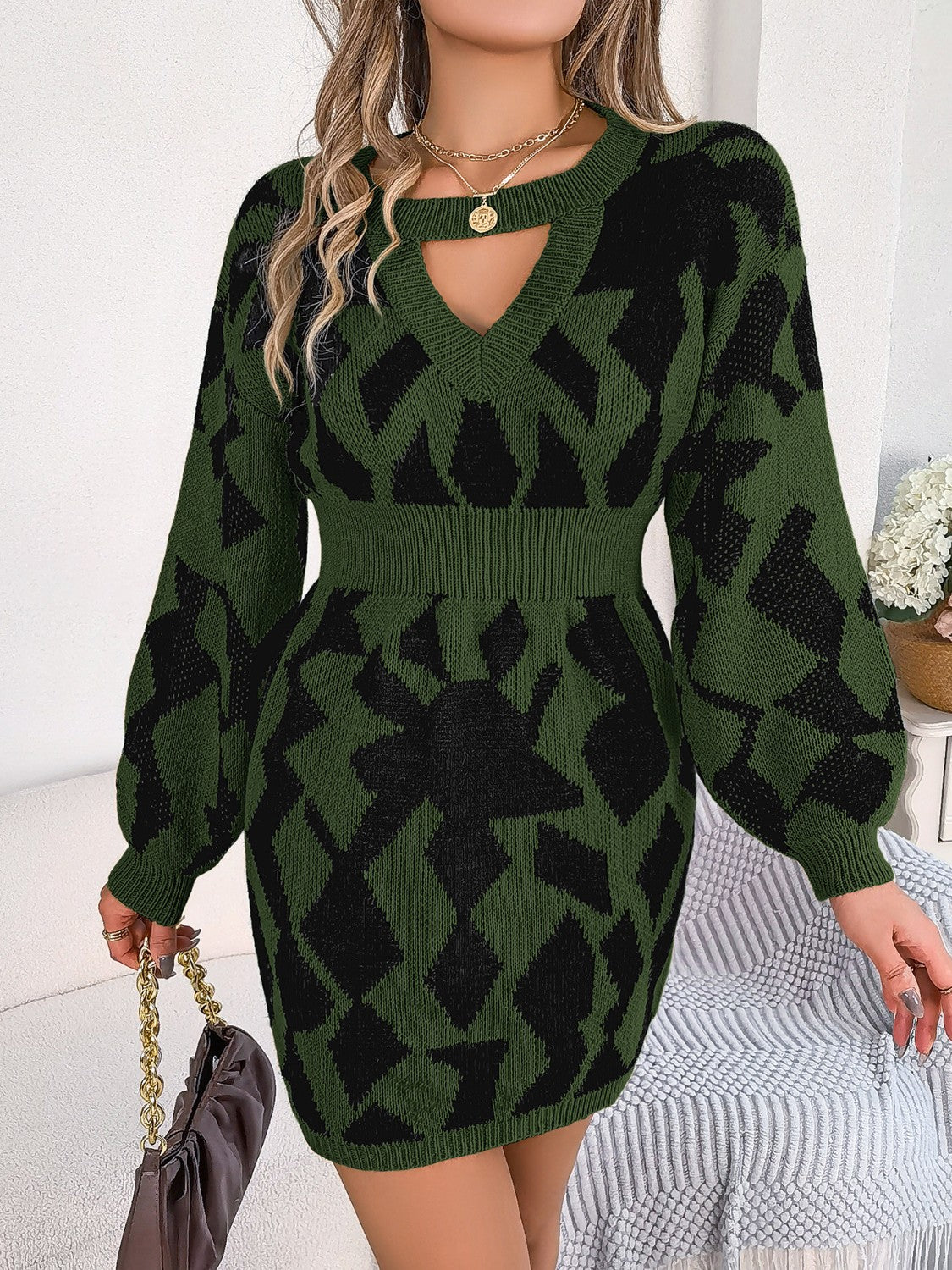 Army green knit mini dress with geometric pattern, V-neck, cutout detail and long sleeves.