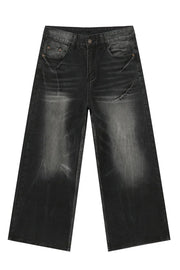 Whiskered wide leg denim jeans in dark wash with a relaxed fit and distressed details.