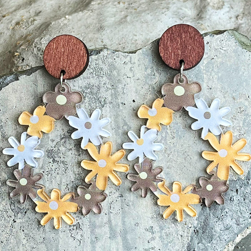 Floral wreath dangle earrings with wood tops and colorful daisy charms.