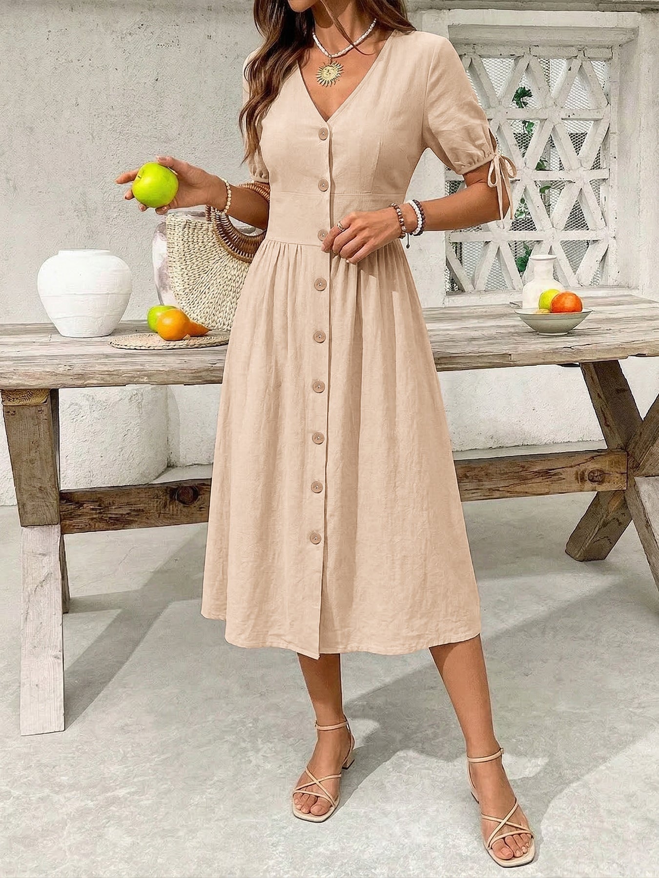 Tan button-down midi dress with tie sleeve details and V-neckline.