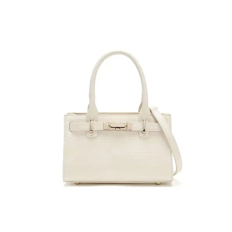 Off-white crocodile-embossed mini tote handbag with a gold buckle closure and top handles.