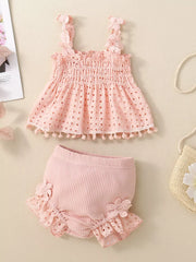 Pink eyelet tank with smocked bodice and pom-pom trim paired with ruffled bloomers.