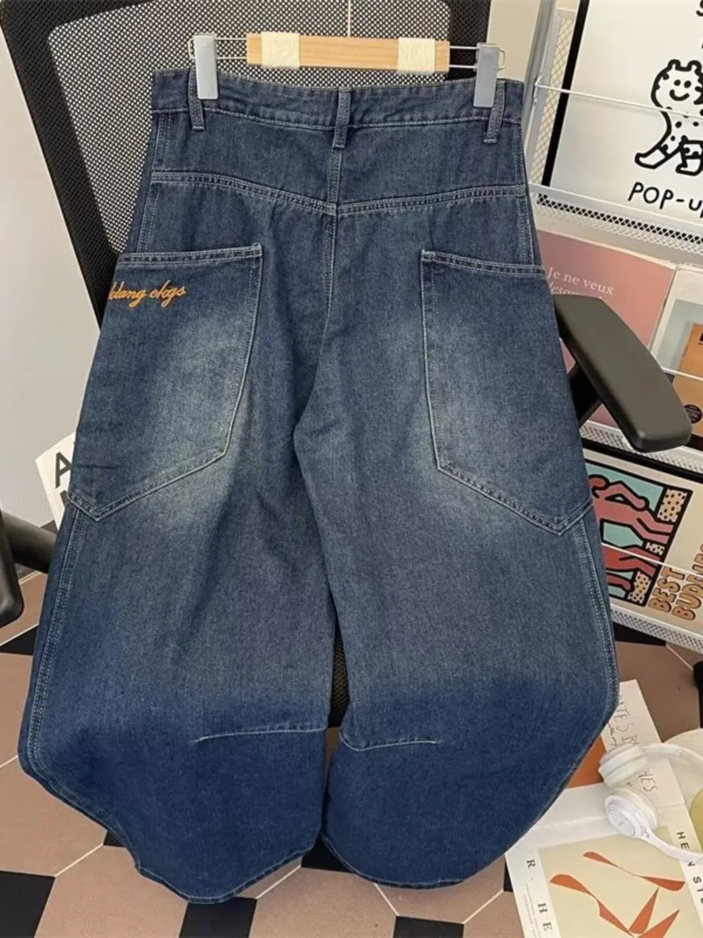 Classic vintage wash wide-leg jeans in dark blue denim with angular pockets and embroidered detail.