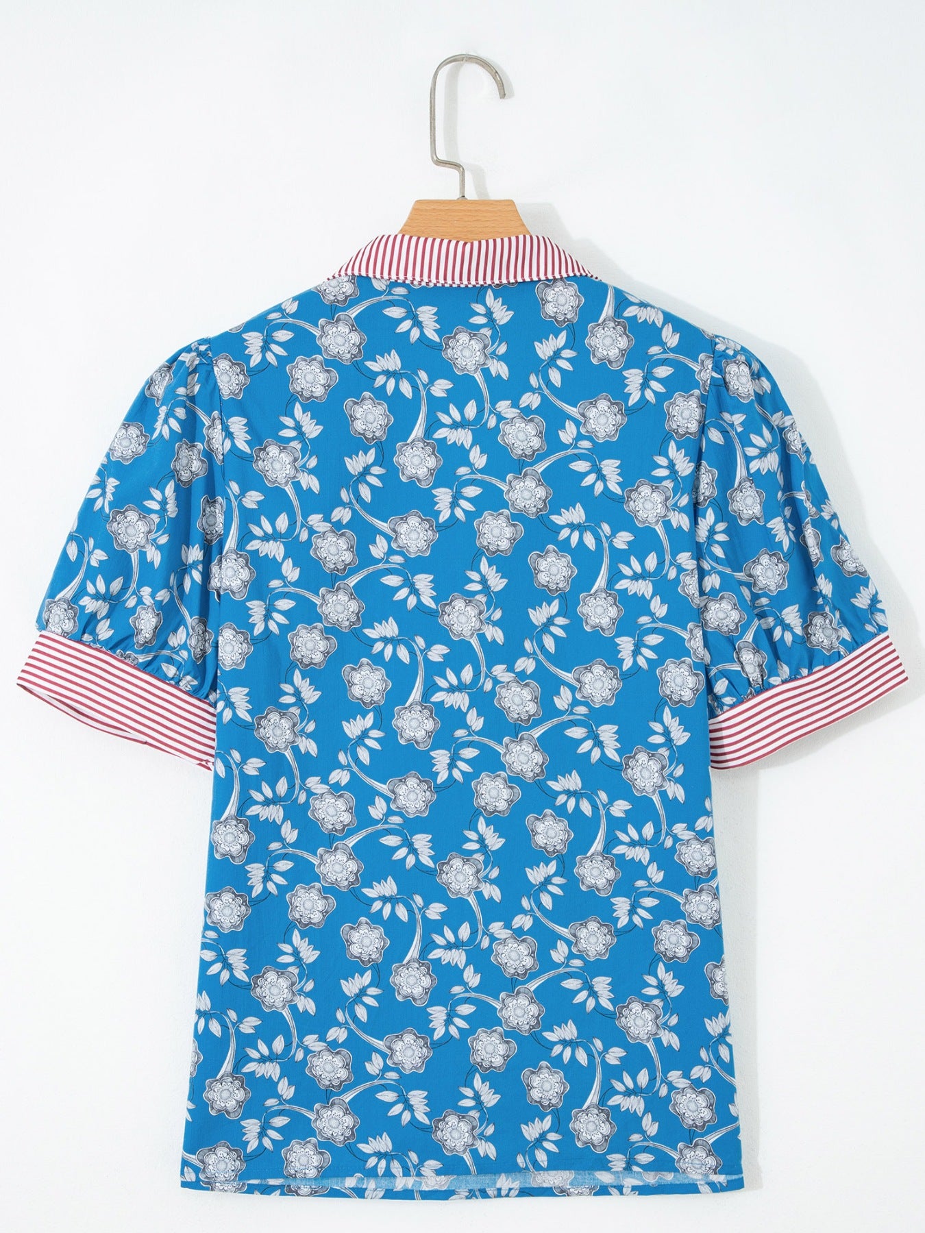 Blue cotton blouse with floral print, puff sleeves, and red and white striped collar and cuffs.