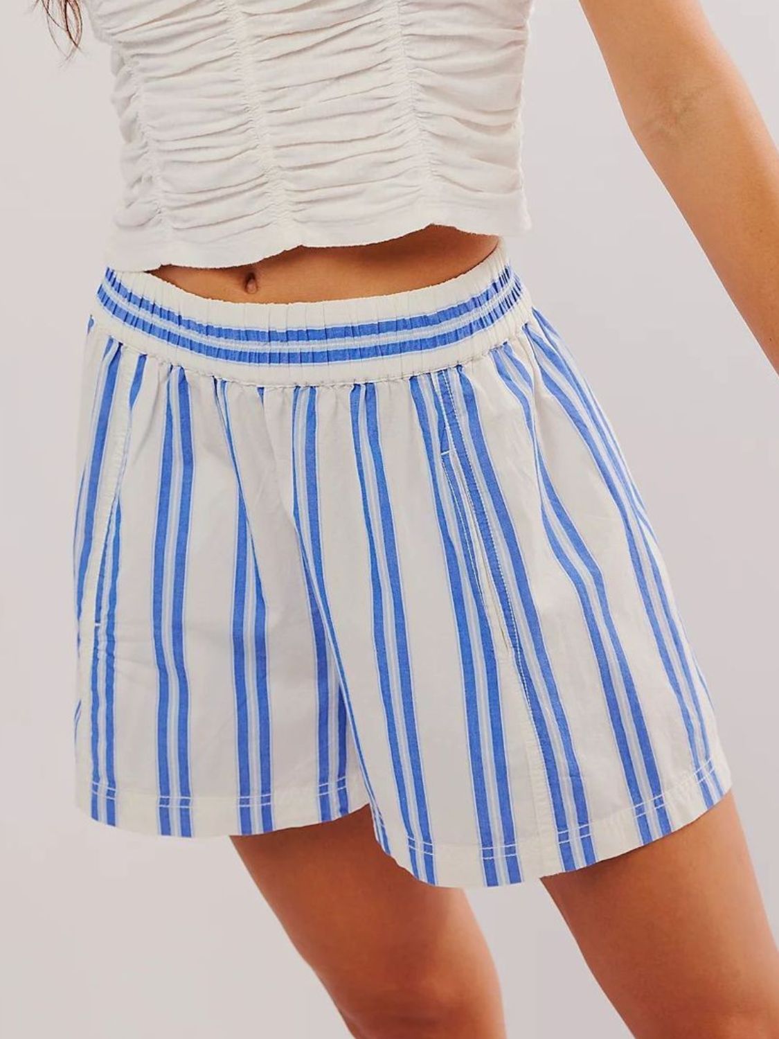 Elastic waistband stripe shorts in blue and white with pockets.