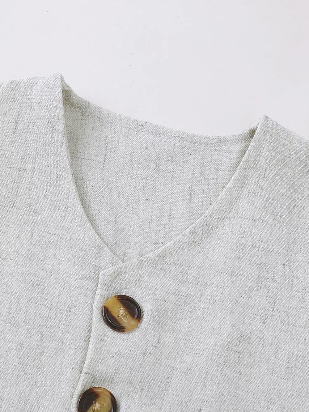 Baby vest set in light grey linen-look fabric with tortoiseshell buttons.