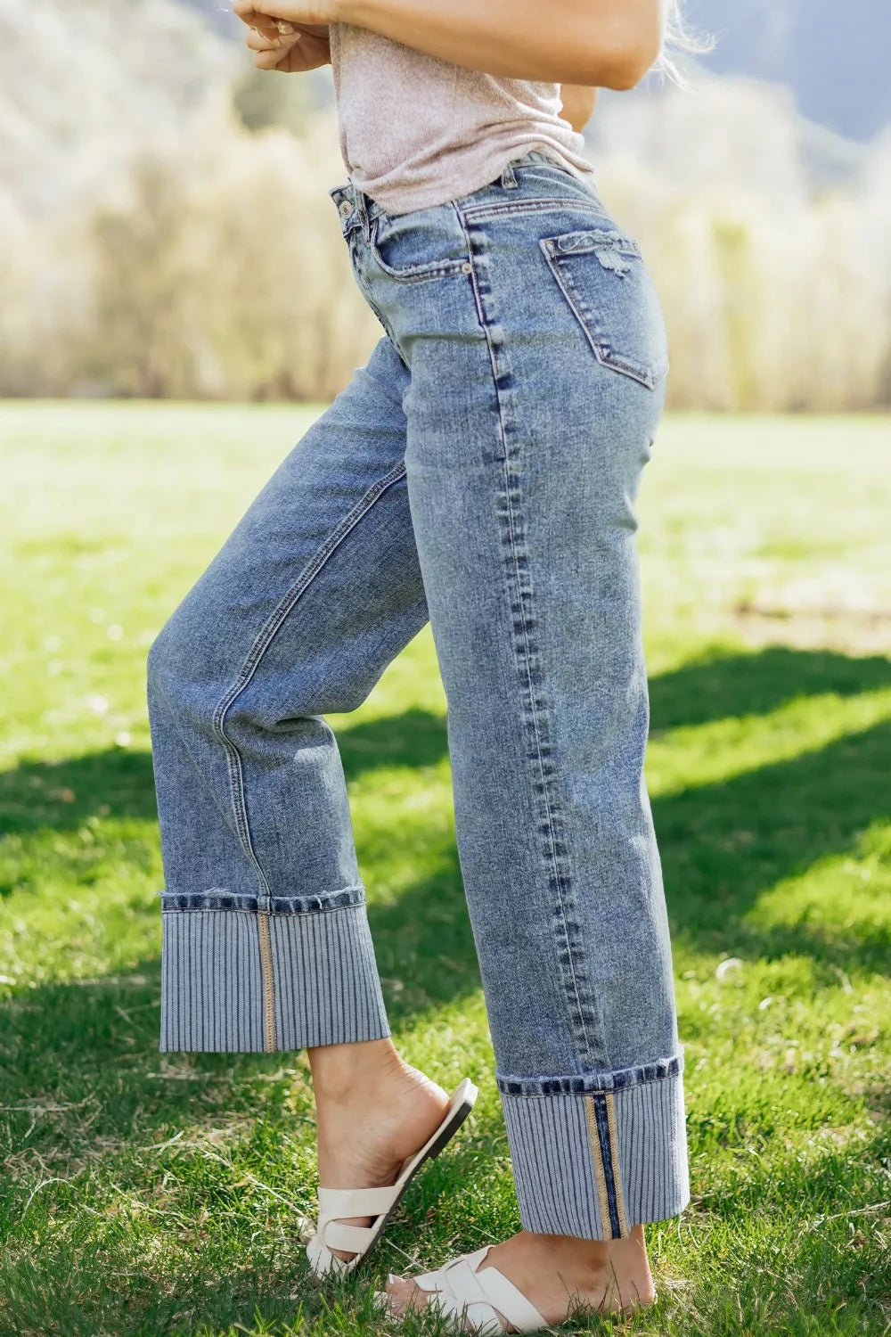 Maternity relaxed fit jeans in light wash denim with distressed details and wide striped cuffs.