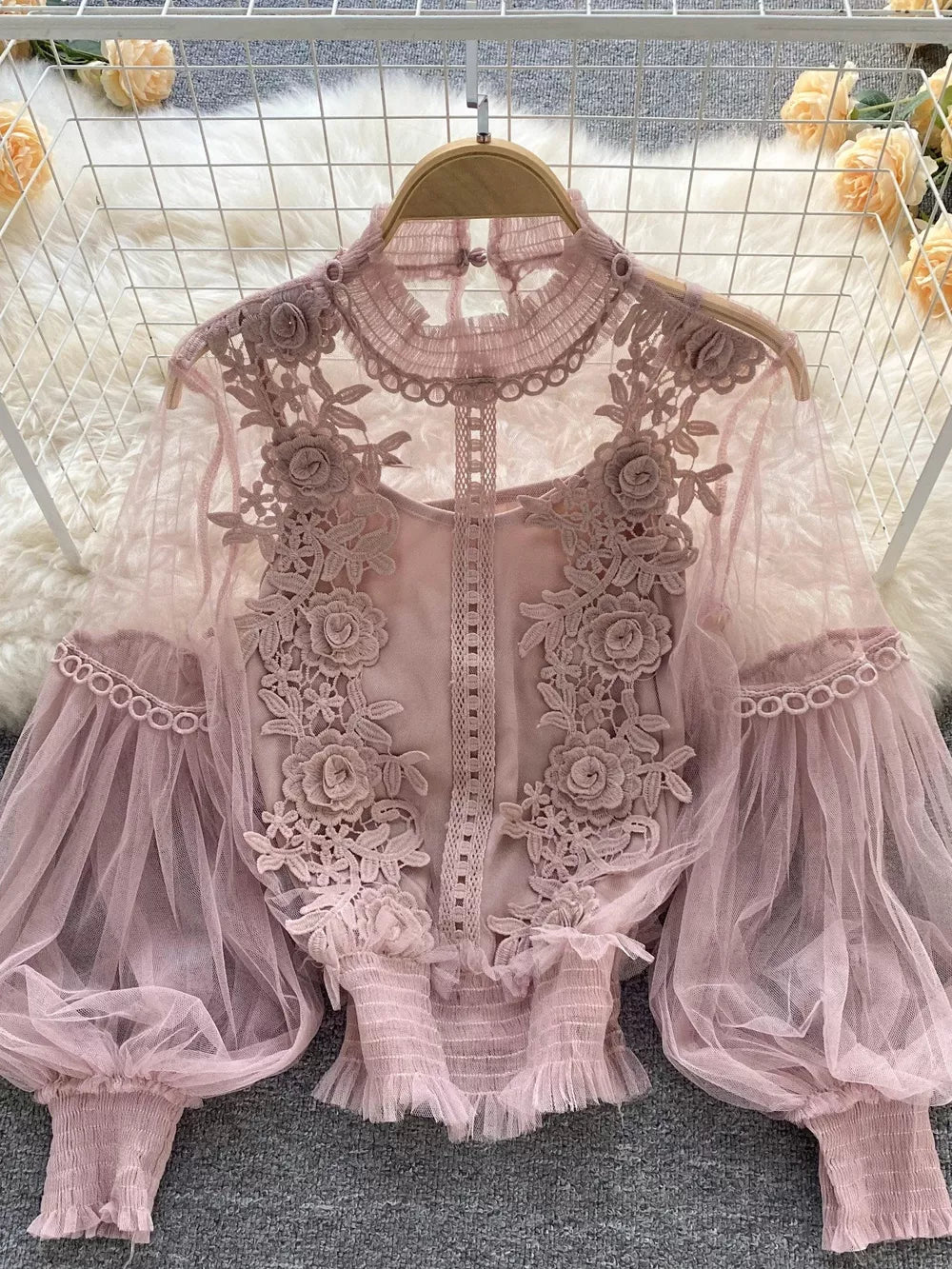 Light pink lace blouse with floral embroidery, sheer puff sleeves, and ruffled hem.