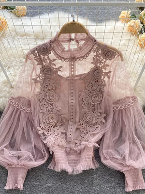 Light pink lace blouse with floral embroidery, sheer puff sleeves, and ruffled hem.