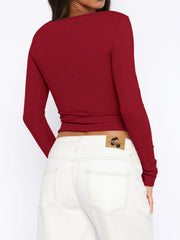 Burgundy ribbed crop top with long sleeves and a button-down front, shown from the back.