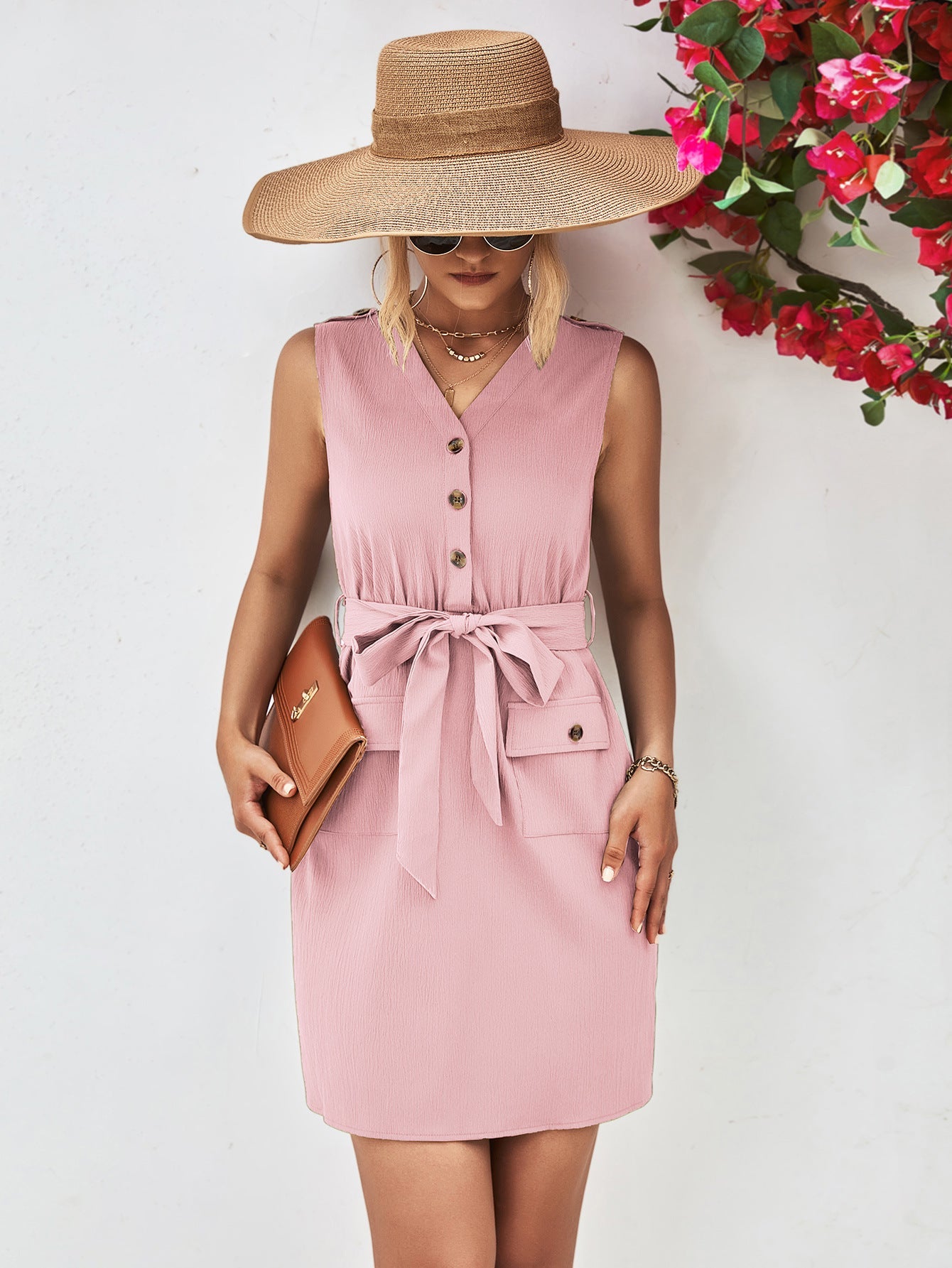 Blush pink button-down tie-waist sleeveless shirtdress with pockets and a belted waist.