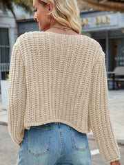 Beige chunky knit cardigan with textured stitch and cropped length.
