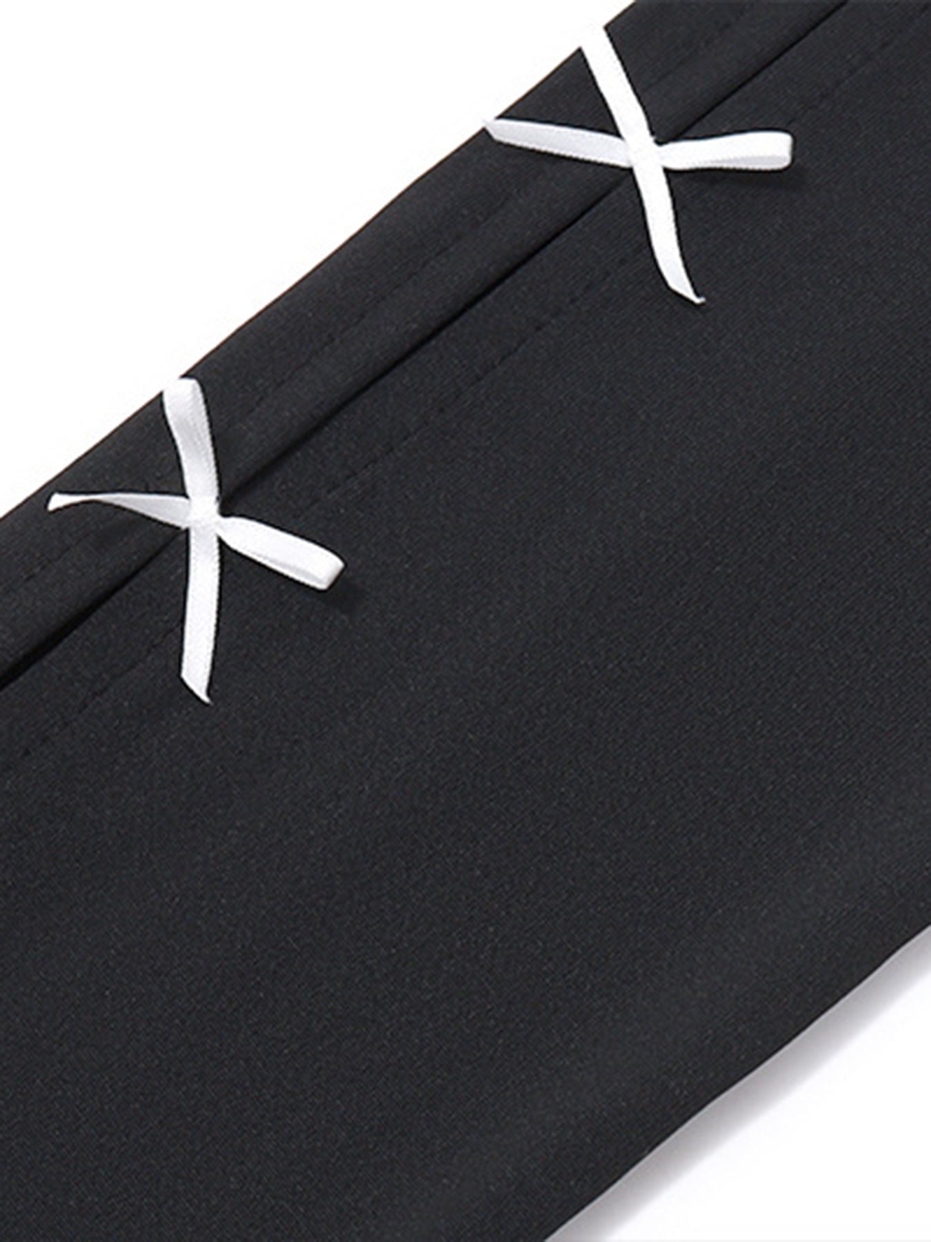 Black mini dress with white bowknot details and contrast stitching.