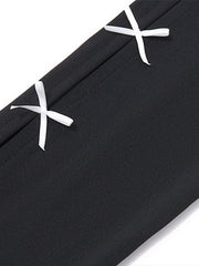 Black mini dress with white bowknot details and contrast stitching.