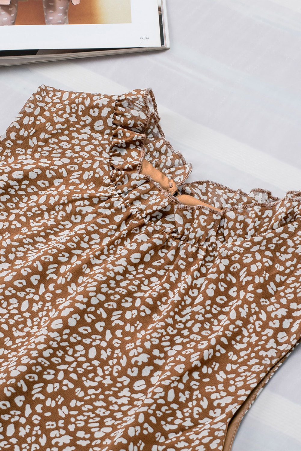 Brown printed sleeveless blouse with ruffled neckline detail