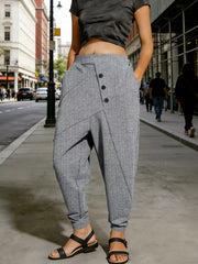 Gray harem pants with decorative buttons and pockets, cuffed ankles.