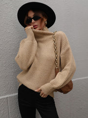 Tan ribbed knit turtleneck sweater with voluminous sleeves.