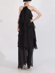 Black cascading ruffle halter maxi dress with sheer wide legs.
