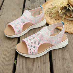 Pink open-toe sandals with a breathable knit upper and white elevated sole.