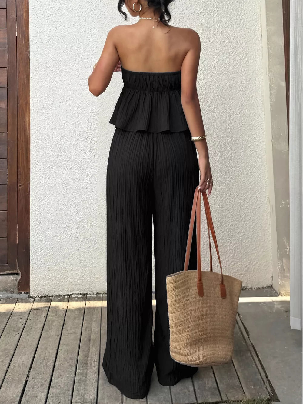 Black strapless peplum top and wide-leg pants set with textured fabric.