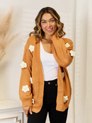 Camel acrylic cardigan with balloon sleeves and white floral appliques.