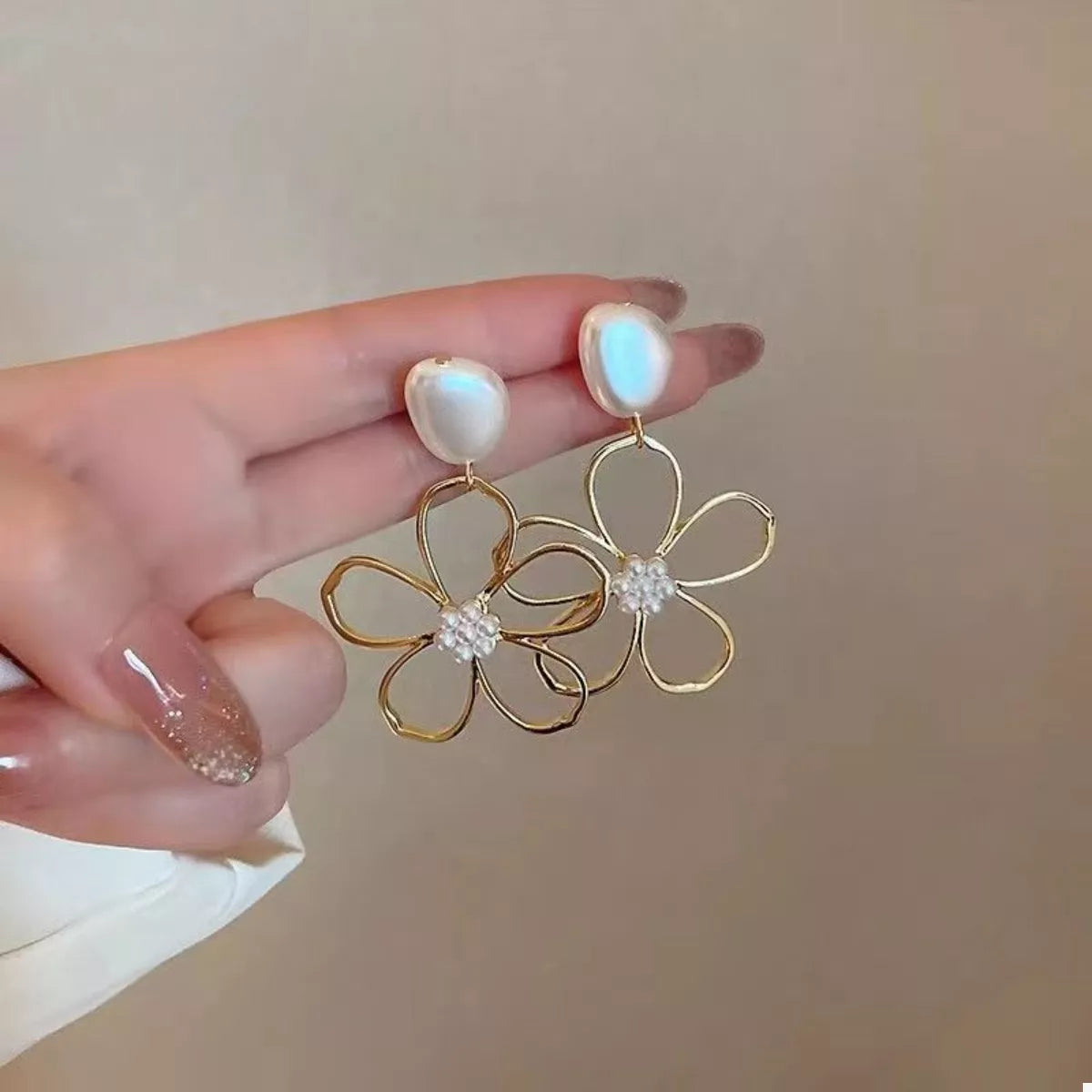 Gold floral drop earrings with pearl and crystal accents.