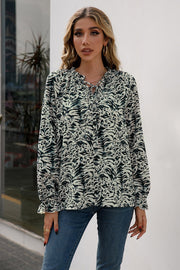 Animal print blouse with ruffle neckline and tie detail, long sleeves.