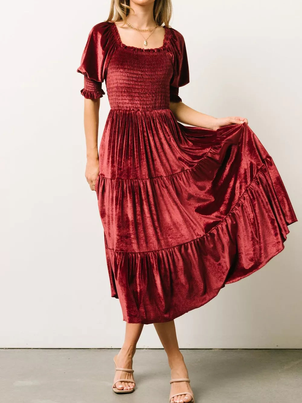Burgundy velvet midi dress with smocked bodice, ruffled short sleeves, and tiered skirt.