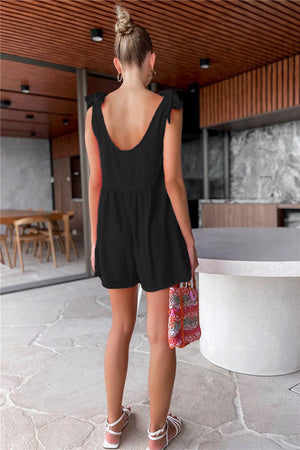 Black gathered waist romper with bow shoulder straps and scoop back.