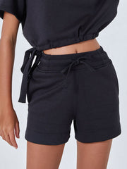 Black drawstring pocket shorts with elastic waistband and tie detail.