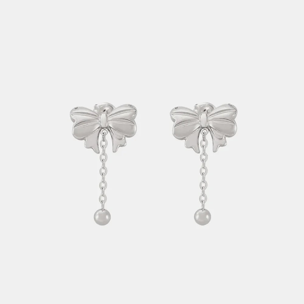 Silver bow drop chain earrings with a ball charm.