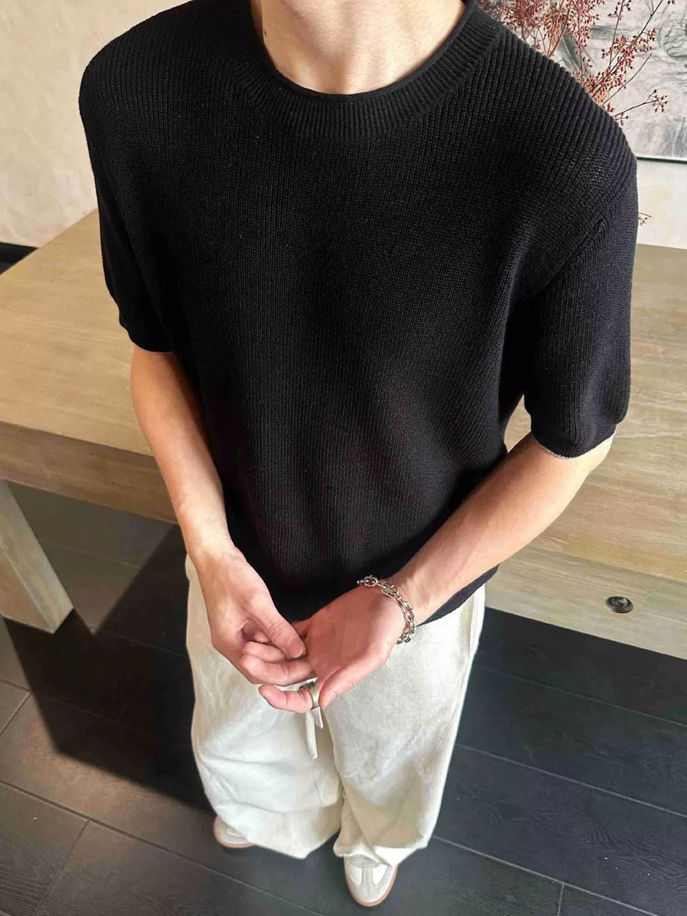 Black short sleeve knit top with ribbed texture and crew neck.