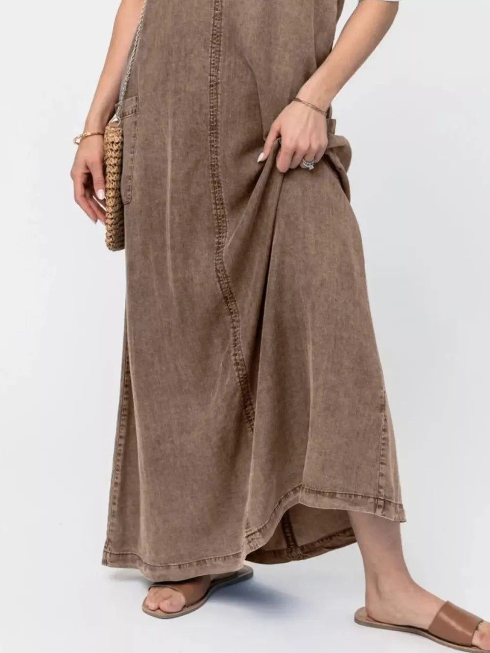 Brown washed denim maxi dress with pocket detail and a flowing skirt.