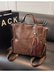 Convertible leather backpack in coffee brown with braided tassel detail and gold hardware.