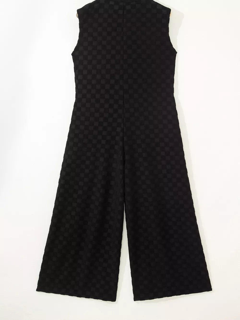 Black checkered wide-leg jumpsuit with a button-front and sleeveless design.
