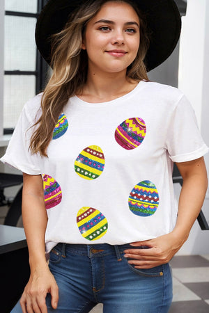 White crewneck tee with colorful sequin Easter egg appliques and rolled sleeves.