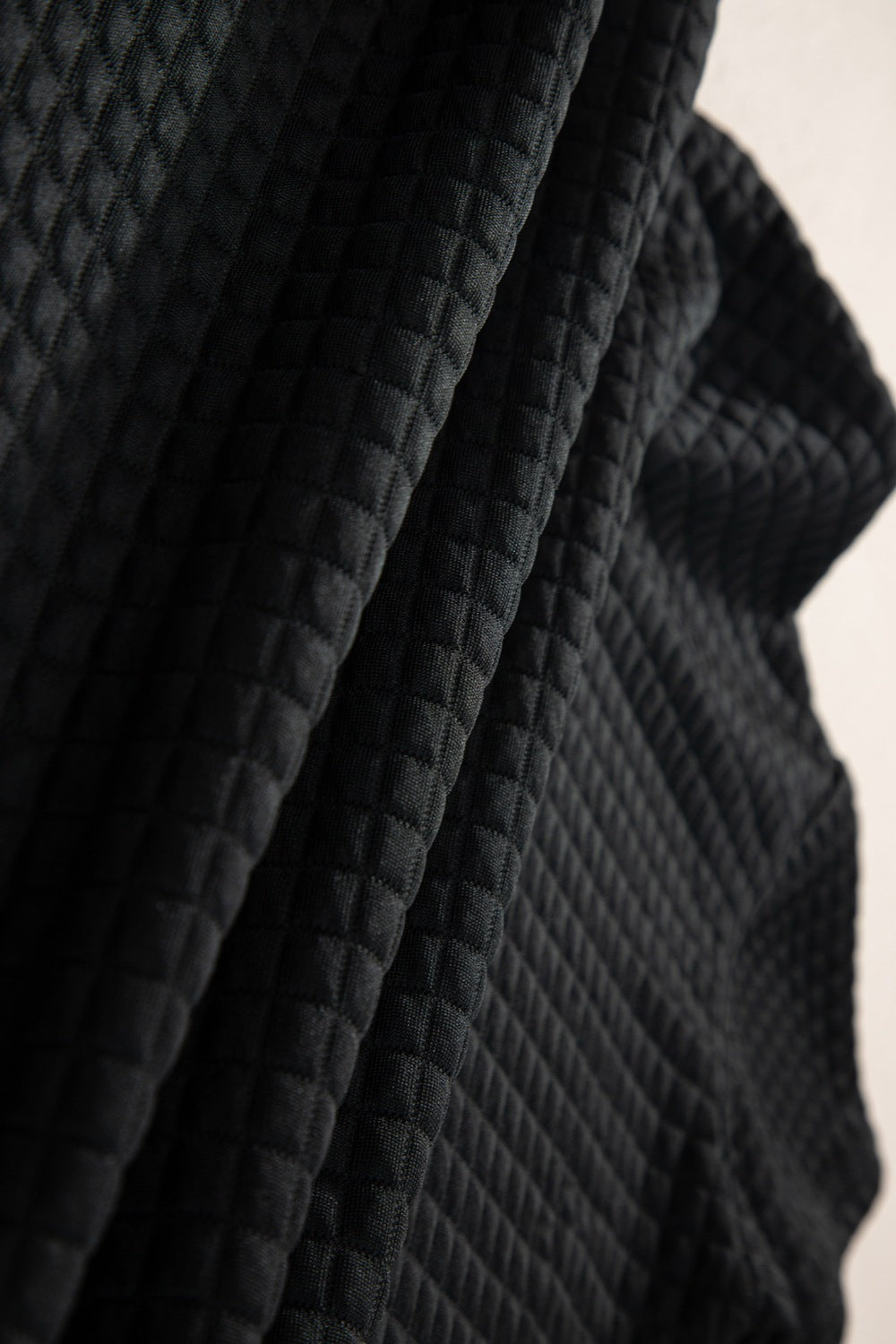 Black quilted knit fabric detail on a crop top and jogger set.