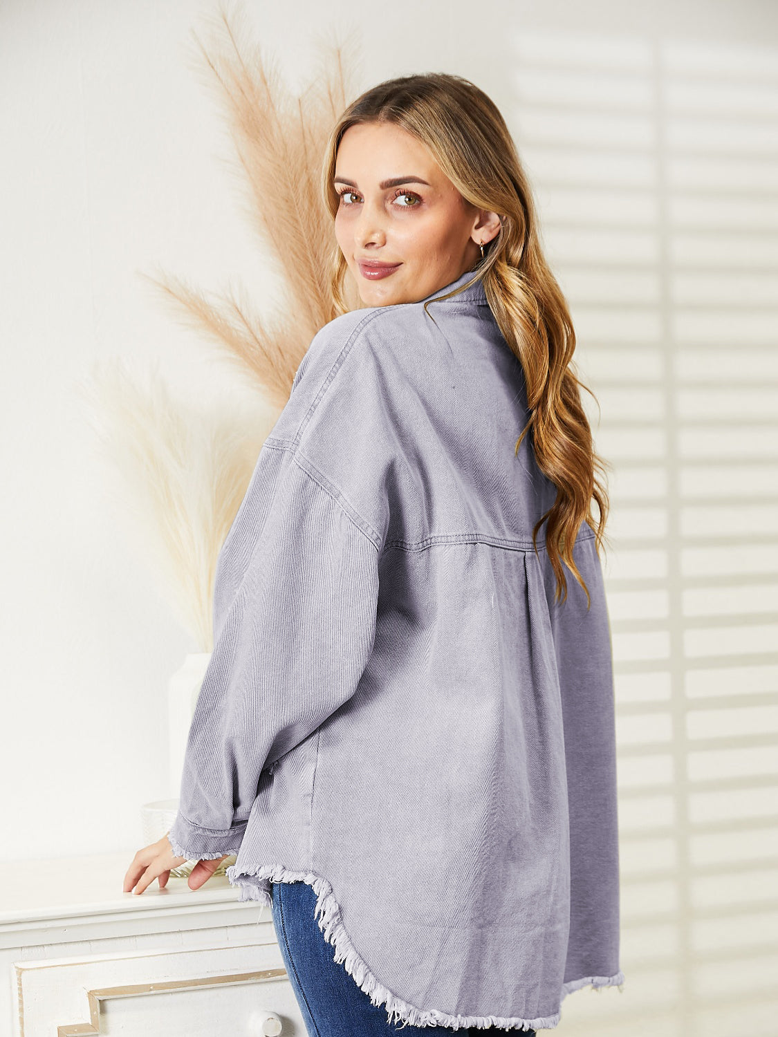 Distressed denim overshirt in lilac with raw hem and buttoned front.