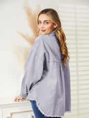 Distressed denim overshirt in lilac with raw hem and buttoned front.