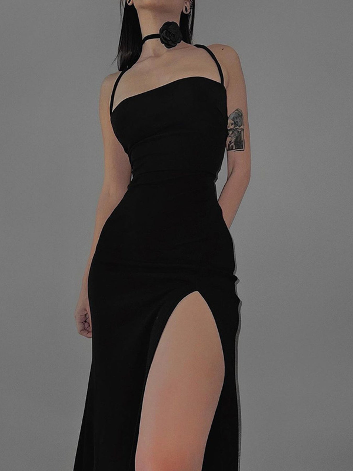 Black backless bodycon maxi dress with high slit and crisscross straps.
