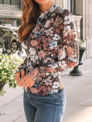 Romantic floral mesh top with mock neck and lettuce trim sleeves, styled with jeans.