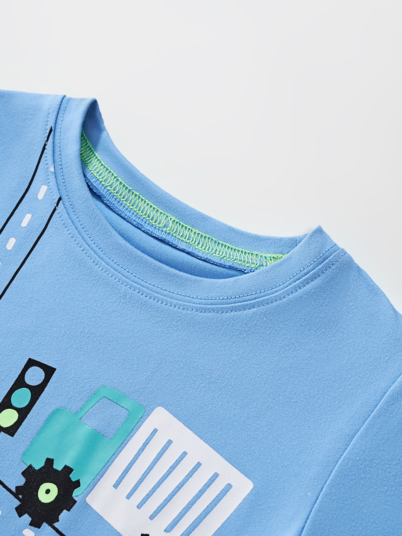 Blue crew neck toddler t-shirt with construction vehicle graphic and green stitching detail.