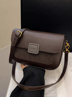 Chic two-tone crossbody bag in coffee brown with a textured panel and gold hardware.