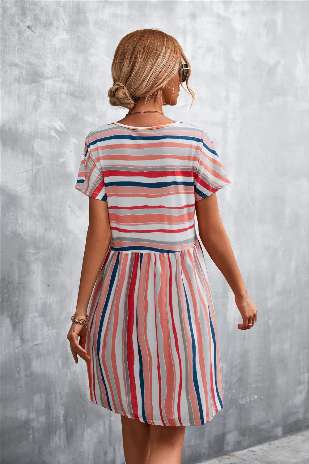 Striped trapeze dress with yoke seam, short sleeves, and a round neckline in coral, navy, and white.
