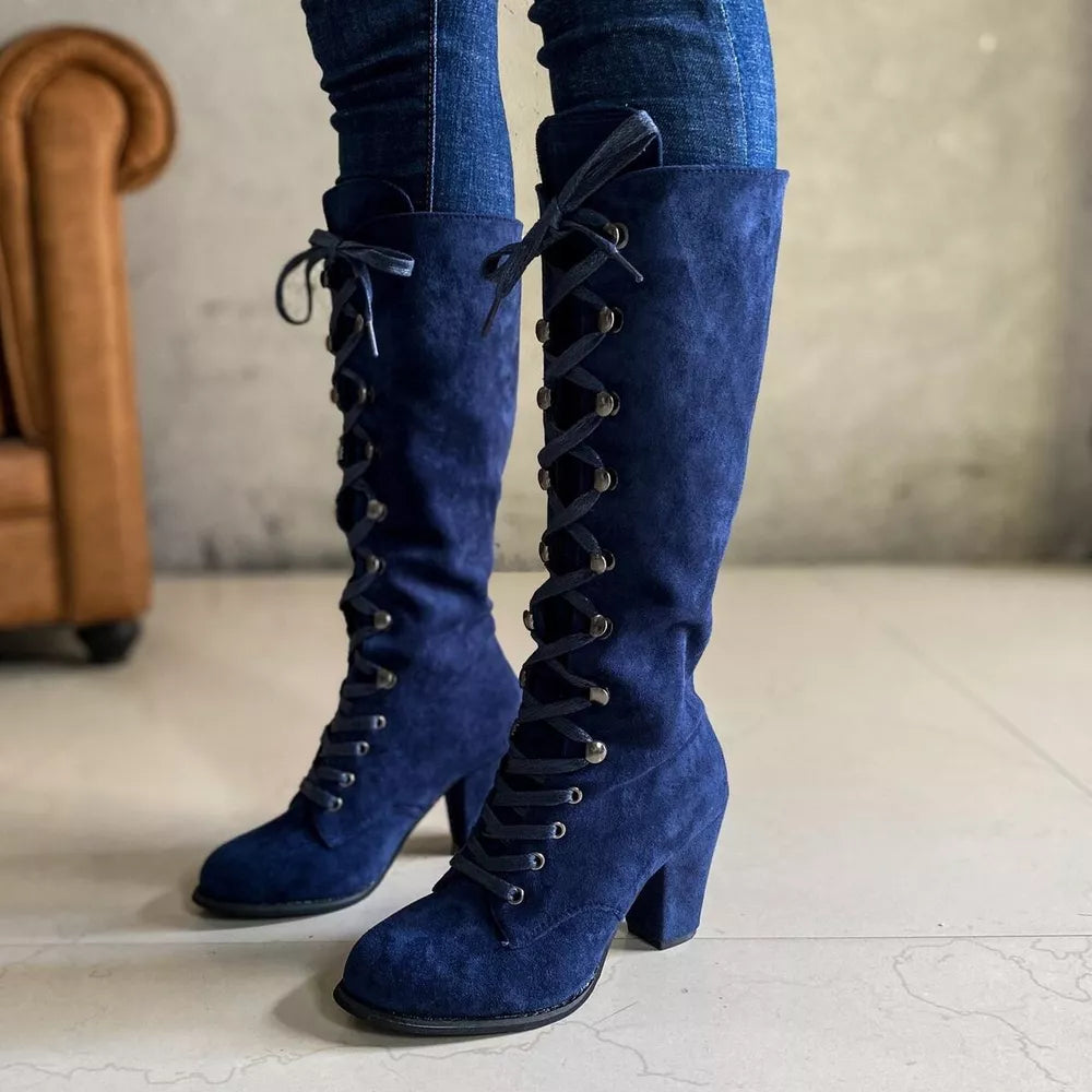 Blue suede lace-up block heel boots with silver eyelets.