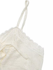 White lace camisole with ruffled hem and tie-front detail.