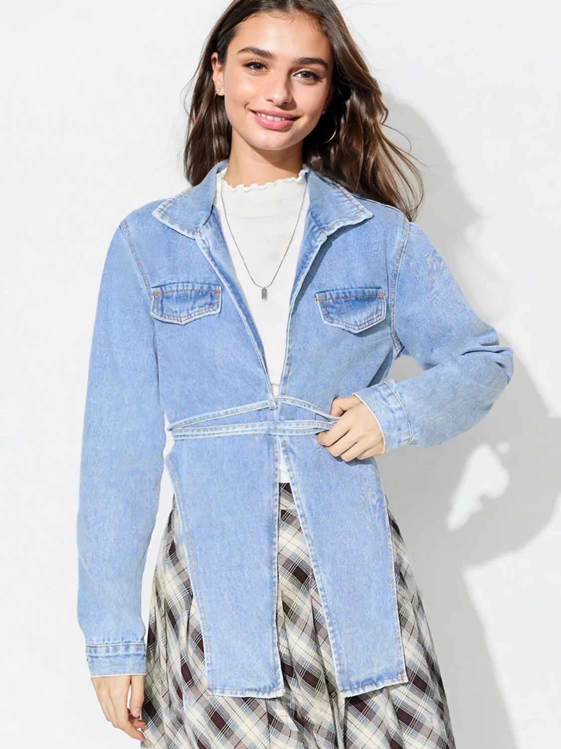 Medium wash denim wrap jacket with tie waist and chest pockets.